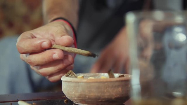 Substance abuse, narcotics and youth, happy boyfriend and girlfriend smoking hashish joint at home. Young man and woman using marijuana cigarette as recreational drug