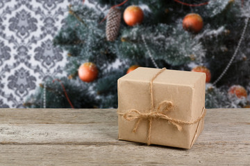 Christmas present on decorated tree background, holiday concept