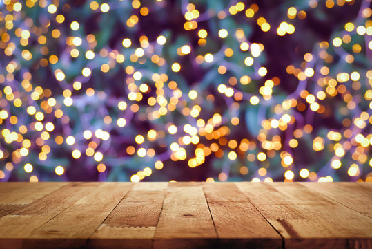 Wood table top with bokeh from decorative light on Christmas tree