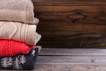 Fototapeta na wymiar Beautiful knitted sweaters on vintage wooden background.