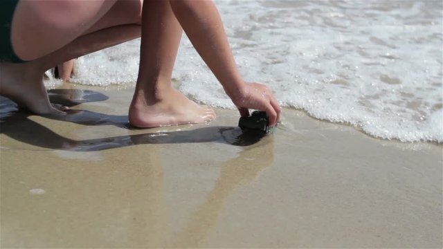 baby playing toy at sea/boy playing toy tanks at sea