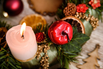 Christmas background with lit candle and rustic ornaments