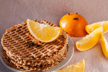 Sliced orange lies on homemade waffles 