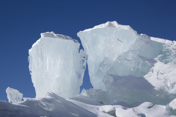 Huge blocks of aqua ice on blue sky background. Winter backdrop.