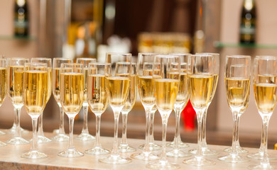 A lot of wine glasses with a cool delicious champagne or white wine at the bar