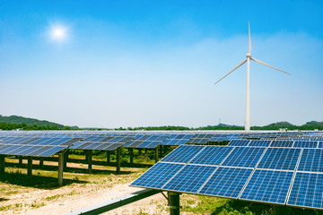 solar panels and wind generators under blue sky on sunset