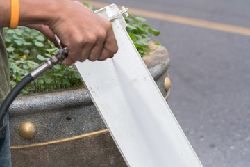 Repairman fixing and cleaning air conditioner unit
