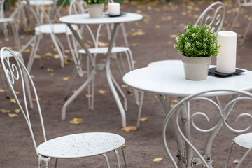 Metal white chairs and tables in park