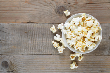 Popcorn in bowl on wooden table