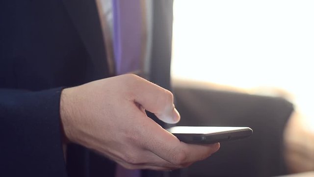businessman smartphone typing message, a man in suit and holding a mobile phone