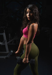 Fototapeta na wymiar Attractive sporty woman in gym background