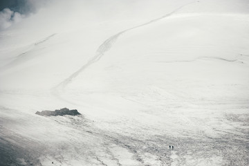 Fototapeta na wymiar Way to the mountain summit at foggy stormy weather Elbrus glacier north side