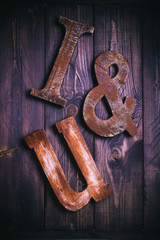 Wooden letters forming words I&U written on wooden background. St. Valentine's Day concept. Top view