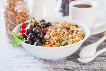 muesli with berries in a plate on a table, selective focus