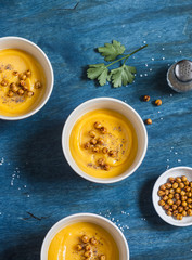 Pumpkin soup with spicy baked chickpea. On a wooden table, top view. Delicious vegetarian lunch. Flat lay