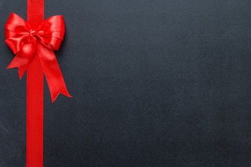 Red ribbon on a black chalkboard