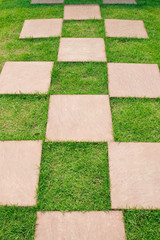 Stone path on green grass background.