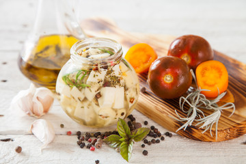 marinated cheese in oil with spices in a jar, selective focus