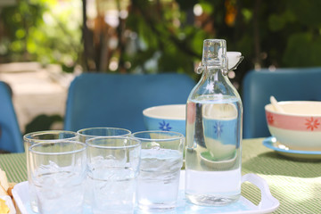 Stock Photo:.Glass of water with a bottle on table