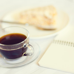 Cup of coffee with cake slice on the bed. Romantic breakfast background.