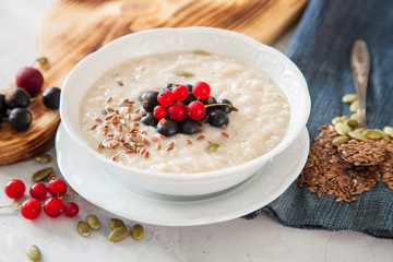 porridge with flax seeds in a bowl on a table, selective focus - obrazy, fototapety, plakaty