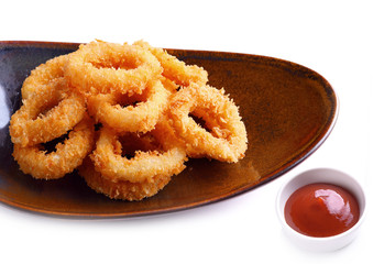Crispy fried squid circle with tomato sauce on white background