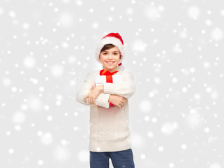 smiling happy boy in santa hat with gift box