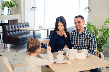 family, parenthood, technology people concept - close up of happy mother, father and little girl having dinner, kid taking photo by smartphone at restaurant