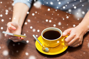 woman with smartphone drinking coffee at cafe