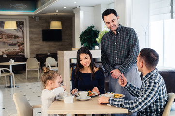 Happy family having breakfast at a restaurant