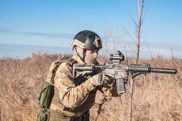 Fototapeta premium airsoft soldier with a rifle playing strikeball outdoor