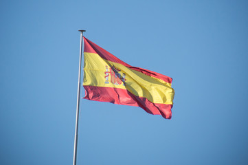 drapeau espagnol flottant au vent sur fond de ciel bleu