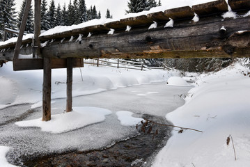 Small water stream, river covered with snow