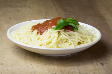 close-up of plate of gluten free spaghetti with tomato sauce and basil