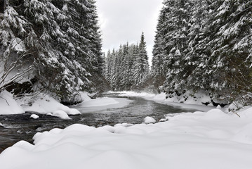 Naklejka premium Winter landscape of a small snowy river