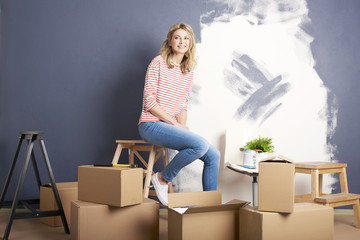 Home renovation diy. Shot of a beautiful mature woman relaxing while painting wall in her new home.