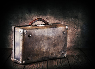 Old leather suitcase on a wooden table
