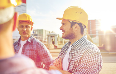 group of smiling builders in hardhats outdoors