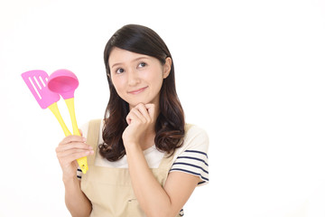 調理器具を持つ笑顔の主婦