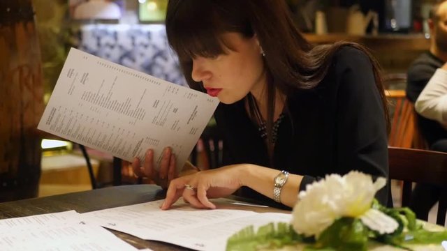 beautiful girl chooses the menu looks