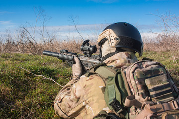 airsoft player in NATO uniform with rifle in ambush close up picture