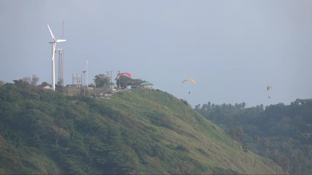 Landscape view with wind mill and three paragliders. Slow motion. Full HD footage 1920x1080
