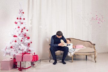Obraz premium family, children, christmas, x-mas, love concept - happy father with adorable baby daughter near christmas tree