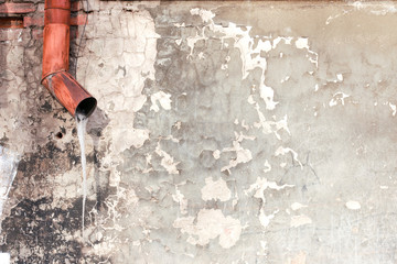 old plastered concrete wall with drain pipe  and icicle