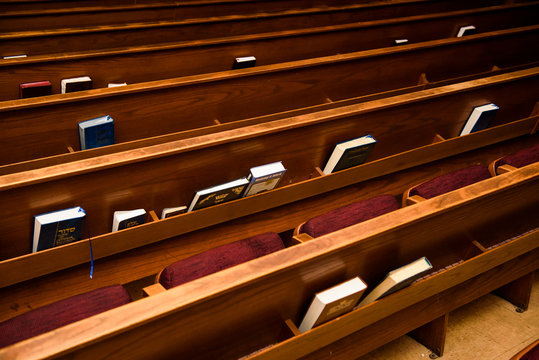 Books stand on shelves on benches in synagogue