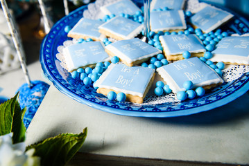 Blue cookies with letterings 'It's a boy!' lie on blue table