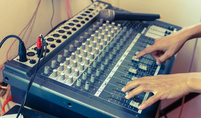 Hand adjusting sound mixer control panel , vintage tone