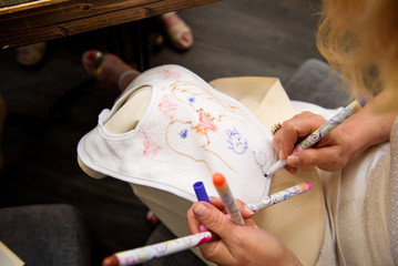 Woman paints something on white bib