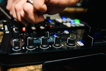 Man touches buttons on DJ's  panel