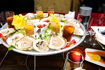 Glasses with cocktails stand on plate with mussels